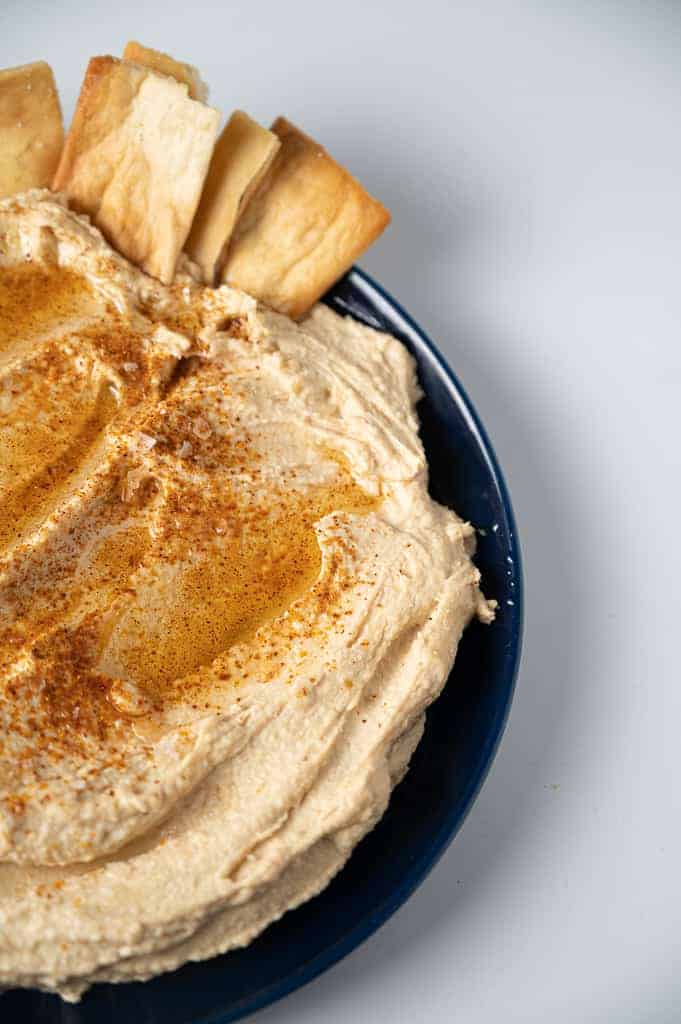 garlic hummus with pita chips on top