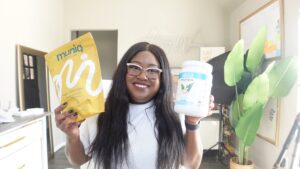Mila holding a bag of muniq and a bottle of vega protein