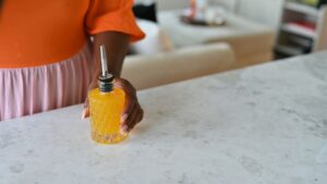 glass bitters bottle with person holding simple syrup