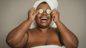Girl practicing self-care with cucumbers on her eyes