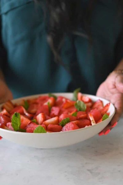 holding bowl of watermelon salad