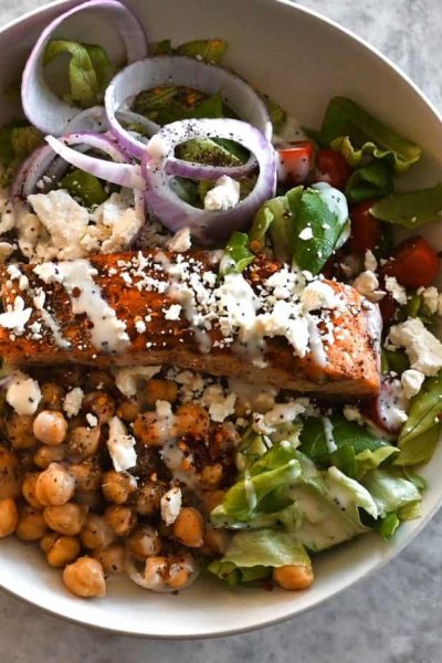 Greek-Style Salad in bowl with salmon on top